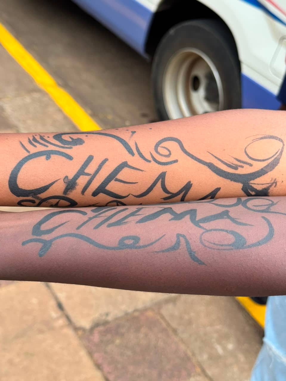 Chema fans display club-themed arm markings before a match.