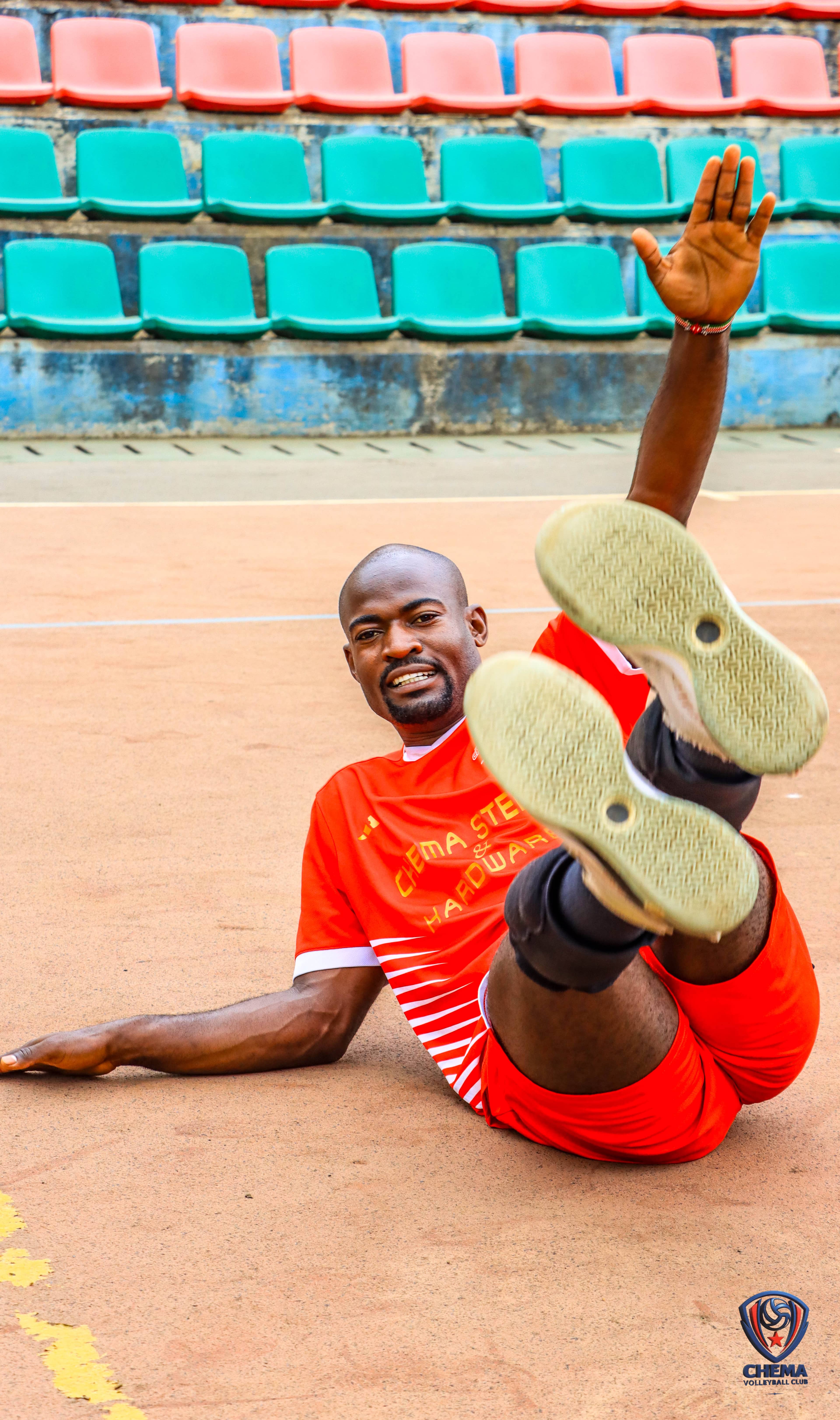 A Chema player in red kit smiles while warming up on court.